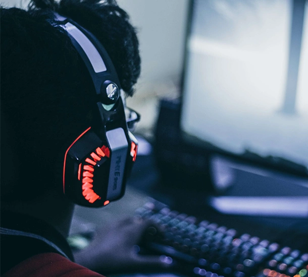 Man bakifrån med lysande hörlurar, lysande tangentbord