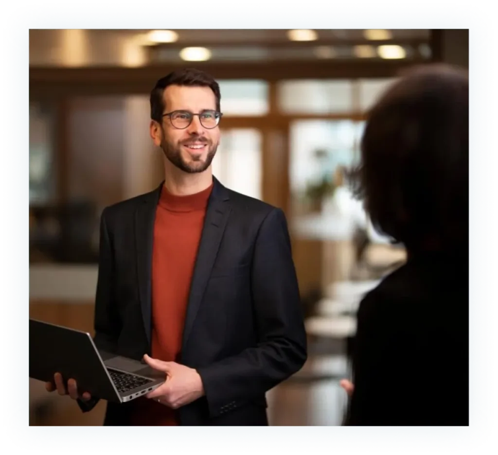 Medarbetare på Valea står med en laptop i famnen