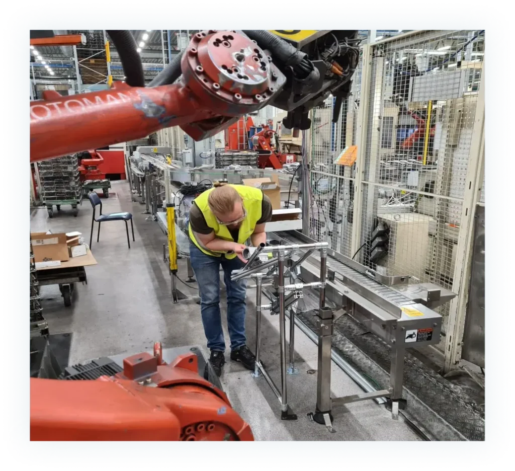 En person arbetar vid en robotarm hos Sansera